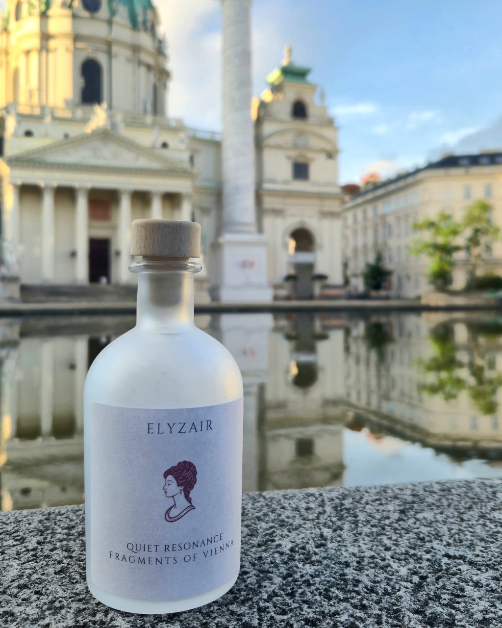 ELYZAIR Quiet Resonance, sealed glass edition of Vienna, on stone beside a reflecting pool